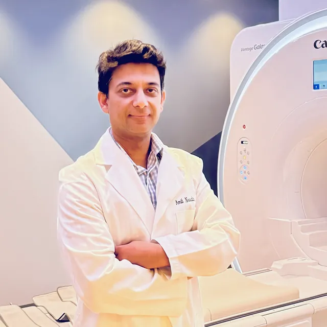 Dr. Amit Newatia, radiologist at Align Radiology, standing beside an MRI scanner